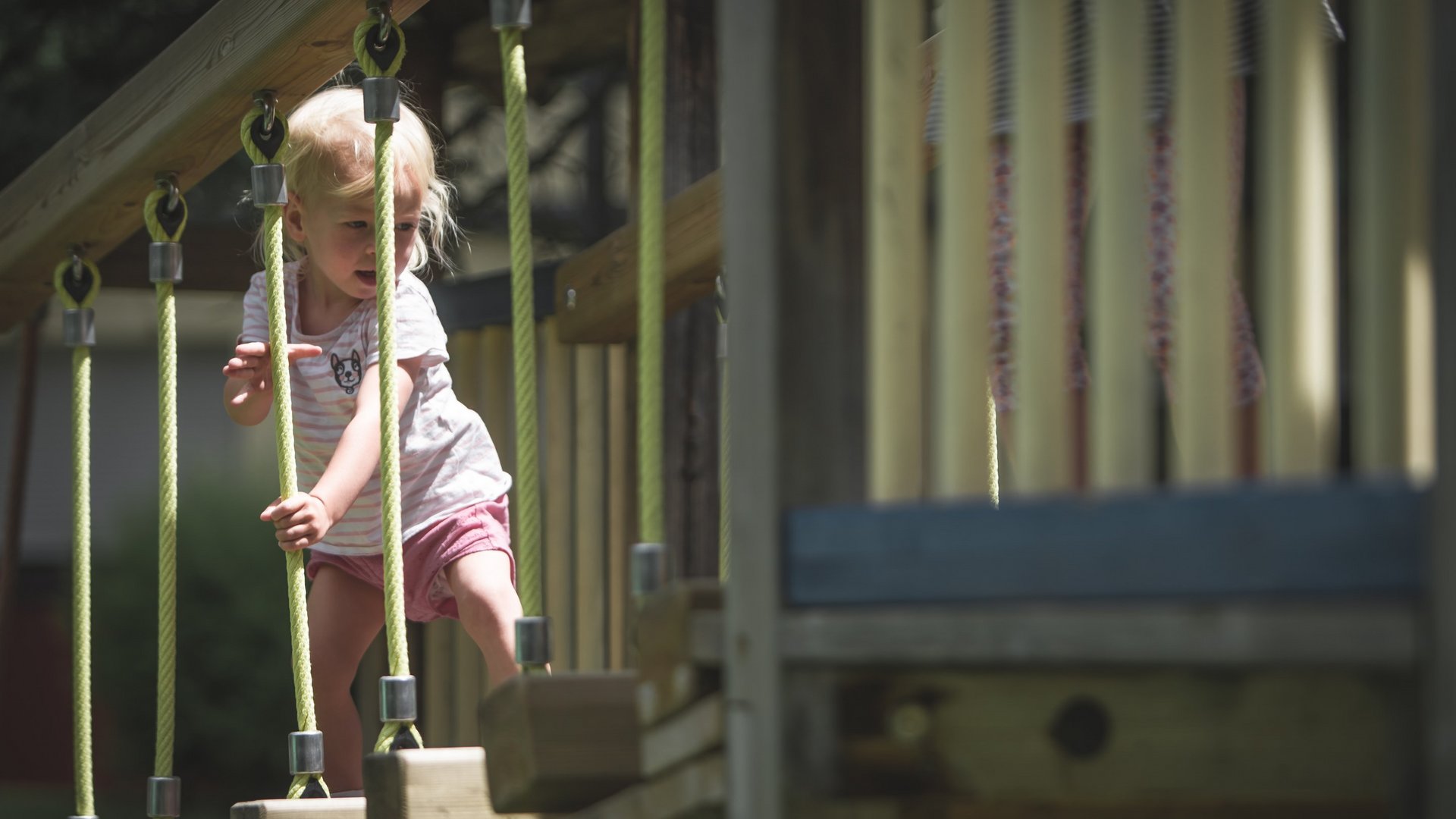 Unterkunft bei Ladurns für Familien Kind klettert auf einem Seilspielplatz im Freien