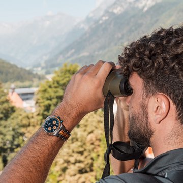 Gudruns Blog: alles über Sterzing, übers Wandern, über Tirol Mann mit Uhr schaut durch Fernglas auf Berglandschaft