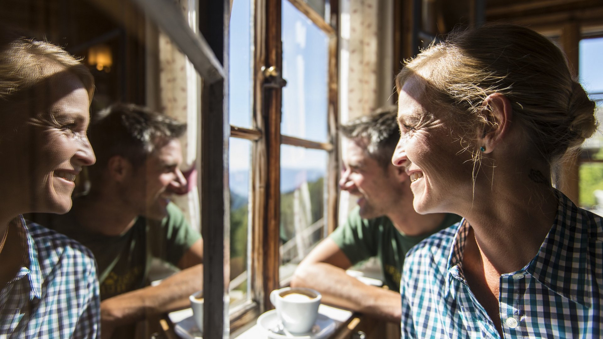 Unterkunft im Pflerschtal gesucht? Frau und Mann lächeln an einem sonnigen Fenster mit Kaffee