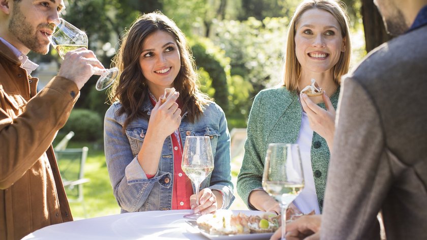 Das Erntedankfest in Sterzing Vier Personen im Freien trinken Wein und essen kleine Snacks