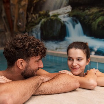Gudruns Blog: alles über Sterzing, übers Wandern, über Tirol Paar entspannt im Pool mit Wasserfallbild im Hintergrund
