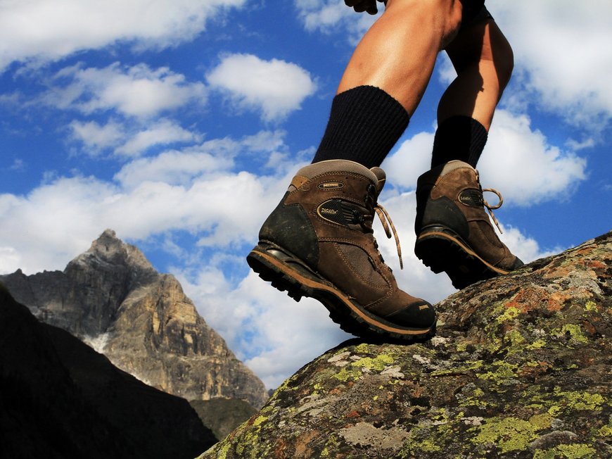 Hotel in Gossensass: welcome to Gudrun! Wanderer mit braunen Wanderschuhen auf felsigem Gelände vor Bergkulisse