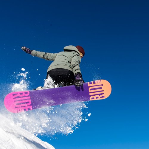Das Skigebiet Ladurns und andere Winter-Highlights Snowboarder springt im klaren blauen Himmel über Schnee