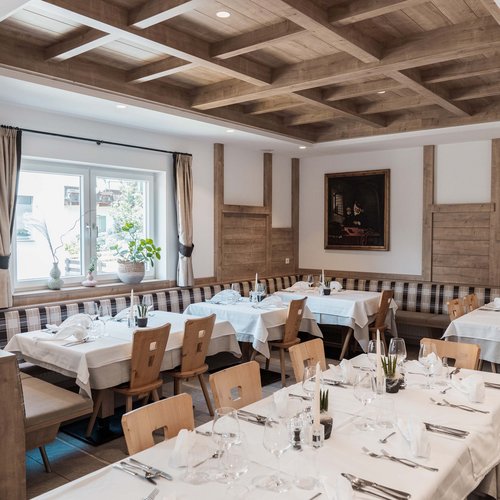 Gudruns Ferienwohnungen: Freiheit im Urlaub Stilvolles Esszimmer mit Holzbalkendecke und gedeckten Tischen mit weißer Tischdecke