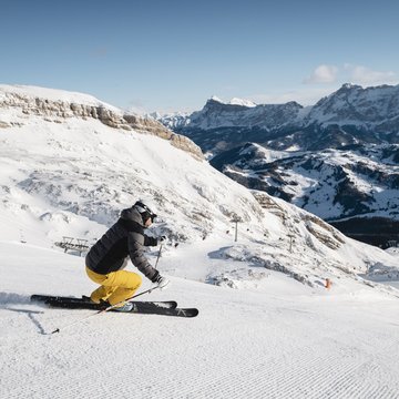 Gudruns Blog: alles über Sterzing, übers Wandern, über Tirol Skifahrer mit gelber Hose fährt auf schneebedecktem Berg mit Alpen im Hintergrund