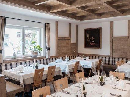 Gudrun in Gossensass: Hotel mit Herz Elegantes Restaurant mit Holzmöbeln und weiß gedeckten Tischen