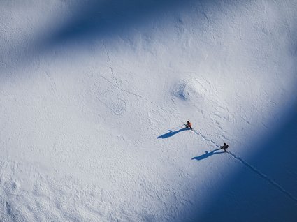 Gudrun in Gossensass: Hotel mit Herz Zwei Wanderer mit Stöcken gehen durch schneebedeckte Landschaft mit Schatten