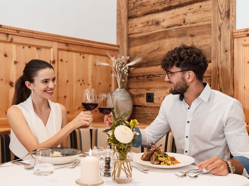 Accommodation in Wipptal: eat at Gudrun Couple toasting with red wine at a restaurant dinner
