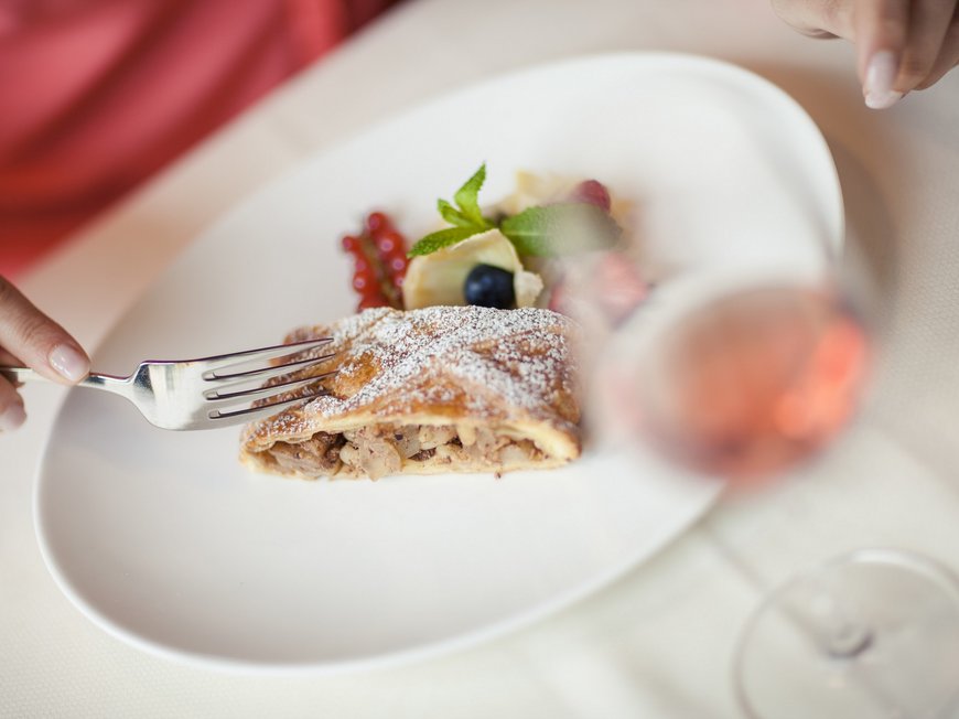 Accommodation in Wipptal: eat at Gudrun Slice of cake with powdered sugar and fresh berries on white plate