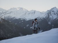 Gudrun in Gossensass: Hotel mit Herz Frau wandert mit Rucksack und Stöcken im schneebedeckten Gebirge