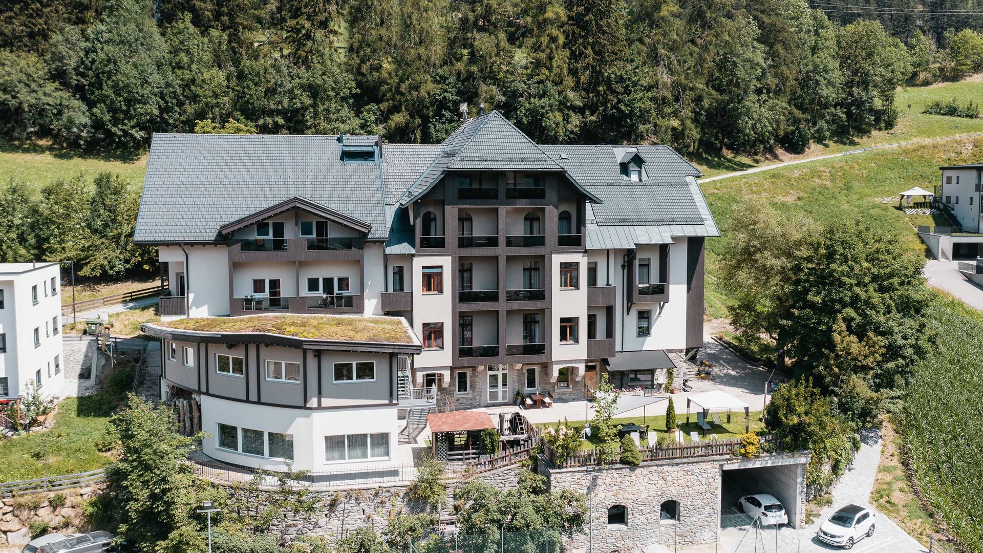 Gudrun in Gossensass: Hotel mit Herz Großes Haus in Alpenlandschaft mit Garten und Wald im Hintergrund