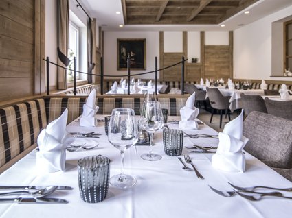Gudrun in Gossensass: Hotel mit Herz Elegantes Restaurant mit gedeckten Tischen und karierten Sitzbänken