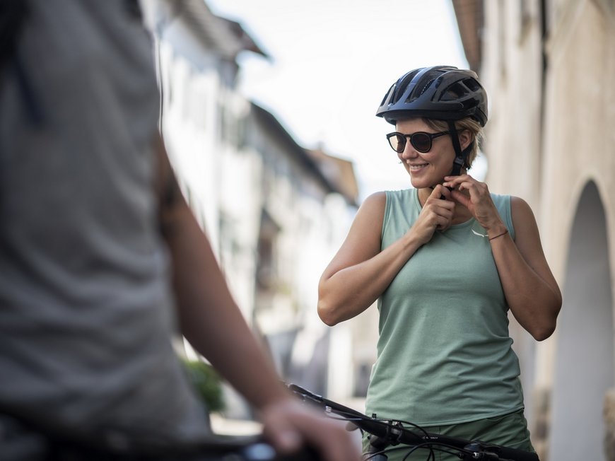 Hiking in Sterzing and the surrounding area Woman fastening bike helmet strap wearing sunglasses