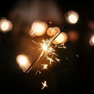 Gudrun in Gossensass: Hotel mit Herz Funkelnde Wunderkerze vor verschwommenen Lichtern in dunkler Umgebung