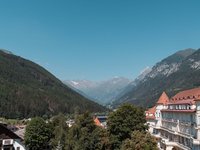 Gudrun in Gossensass: Hotel mit Herz Bergtal mit Wald und Gebäuden unter klarem blauen Himmel