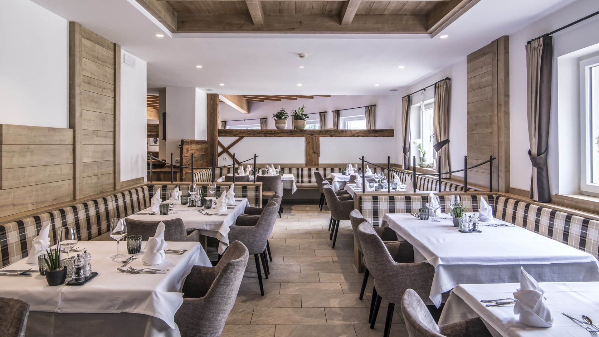 Gudrun in Gossensass: Hotel mit Herz Helles Restaurant mit Holzbalkendecke und gedeckten Tischen mit weißen Tischdecken