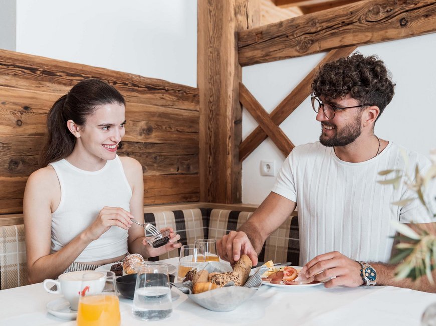 Accommodation in Wipptal: eat at Gudrun Couple having breakfast together with bread rolls and drinks at the table
